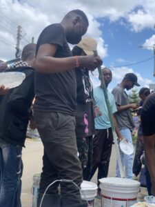 Angaza team and children gathered around a finished mural project